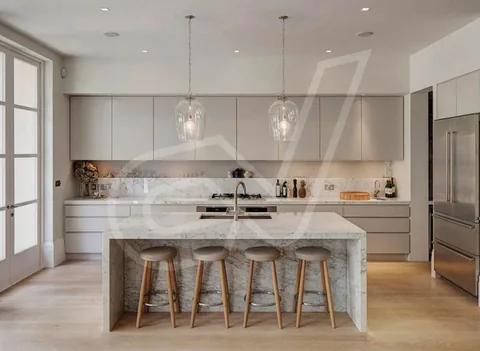 Cocina en tonos claros con isla central y taburetes de madera