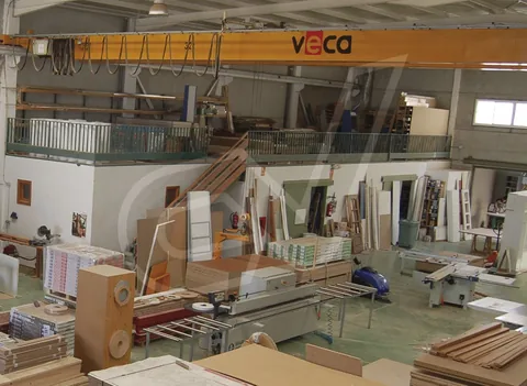 Nave de fabricación con puente grúa y material apilado