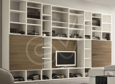 Librería blanca de suelo a techo con módulos abiertos y hueco para el televisor