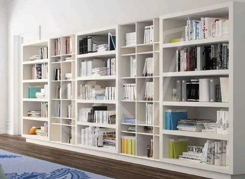 Librería blanca de gran longitud con baldas colocadas a distintas alturas