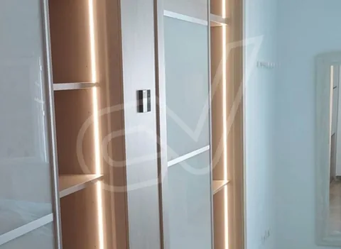 Armario de puertas correderas con frentes de madera y perfil metálico