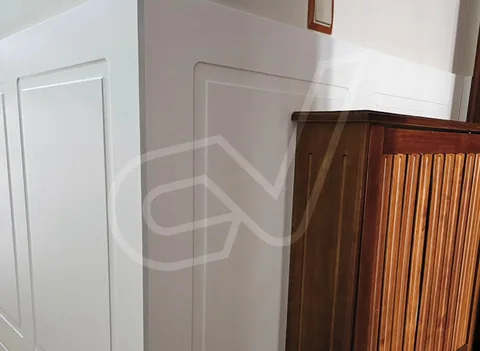 Puerta blanca de cuarterones junto a un mueble de madera