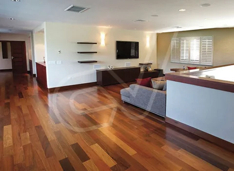 Suelo de madera de tono rojizo en una vivienda diáfana
