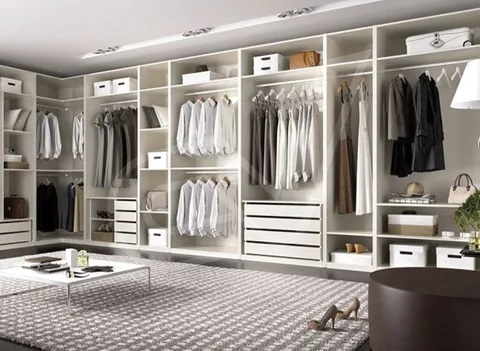 Vestidor amplio con módulos claros, cajones e iluminación superior