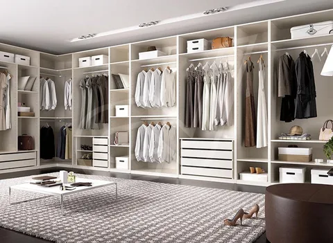 Vestidor claro con isla de cajones y zona de espejo
